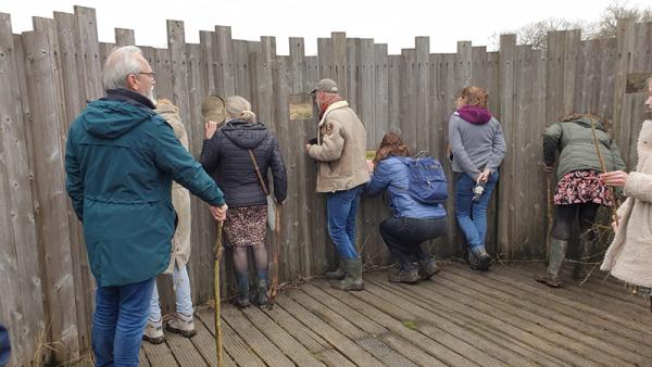 Bezoekers kijken naar vogels door kijkscherm in Waterdunen