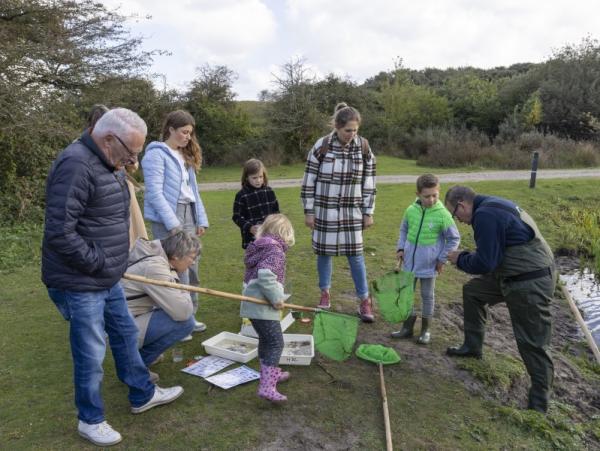 Kinderen en volwassenen met schepnet tijdens ronde van Oranjezon