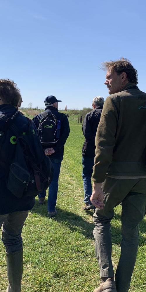 Excursiedeelnemers lopen door Waterdunen