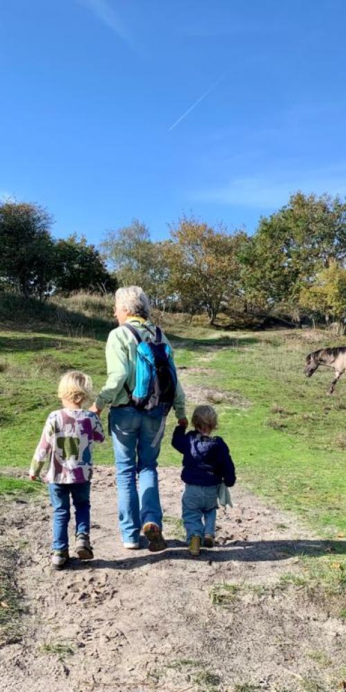 Oma loopt met twee kleinkinderen door Oranjezon