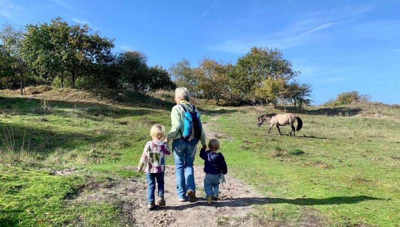 Oma loopt met twee kleinkinderen door Oranjezon