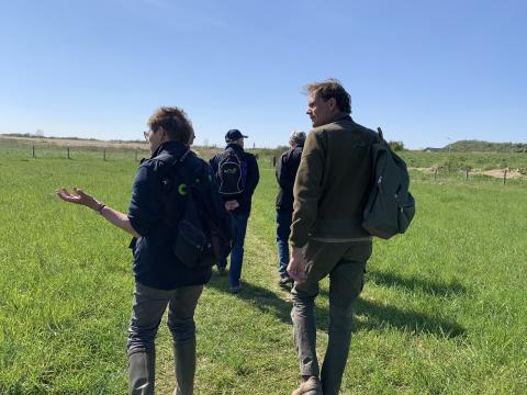 Excursiedeelnemers lopen door Waterdunen