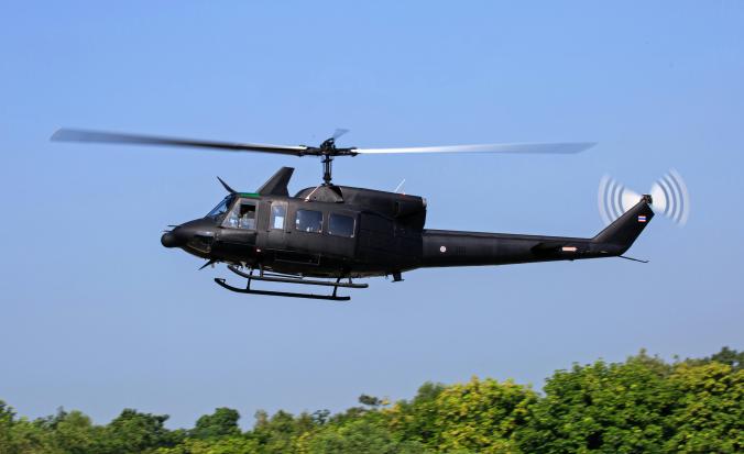 Helikopter vliegt boven bomenrij